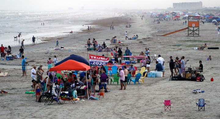 People gather on the beach for the Memorial Day weekend in Port Aransas, Texas, Saturday, May 23, 2020. Beachgoers are being urged to practice social distancing to guard against COVID-19. (AP Photo/Eric Gay)