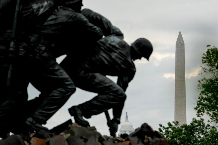 The Dome of the U.S. Capitol Building and the Washington Monument are visible behind the U.S. Marine Corps War Memorial on Memorial Day, Monday, May 25, 2020, in Arlington, Va. (AP Photo/Andrew Harnik)