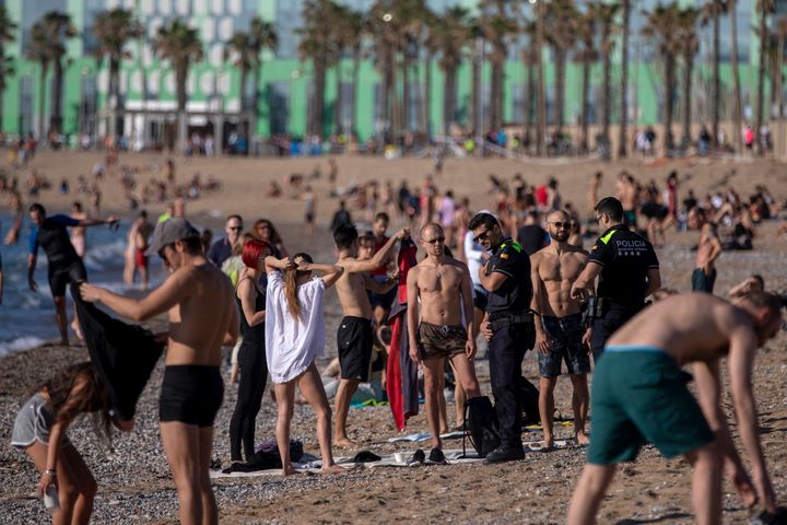 Police officers ask people to not sit while patrolling at the beach in Barcelona, Spain, Wednesday, May 20, 2020. (AP Photo/Emilio Morenatti)