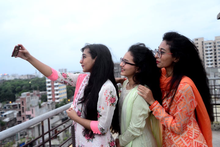 Muslims girls wearing new dresses take a selfie to celebrate in Dhaka, Bangladesh, on Monday.