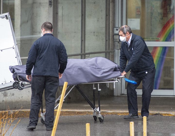 Funeral home workers remove a body from the Centre d'hebergement Ste-Dorothee on April 13, 2020 in Laval, Que. 