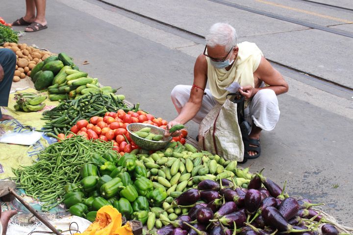 People buy vegetables from a market in Kolkata after the government eased lockdown on May 25, 2020. 