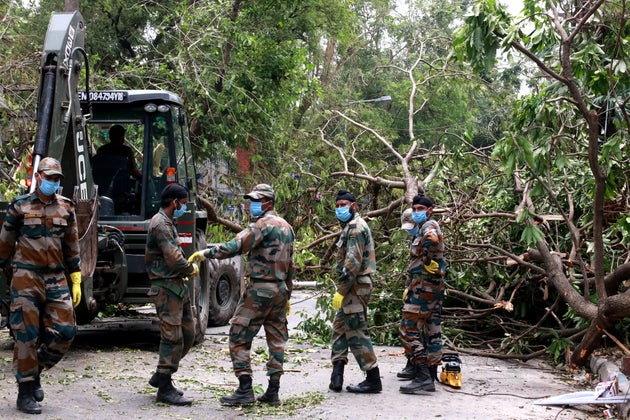Army Jawans work to clear trees uprooted by cyclone Amphan from a road in Kolkata after cyclone Amphan...