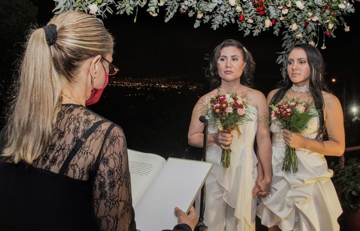 Alexandra Quiros (C) and Dunia Araya (R) stand before a lawyer during their wedding in Heredia, Costa Rica, Tuesday. 