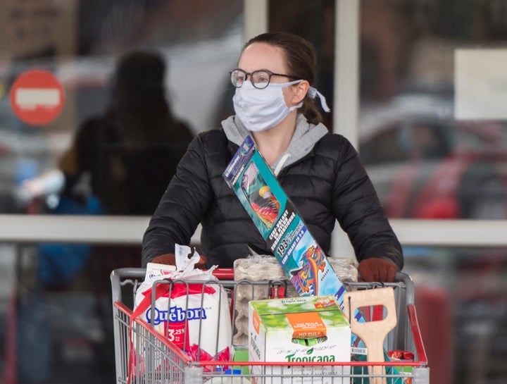 A woman wears a mask as she leaves a grocery store in Montreal on April 10.