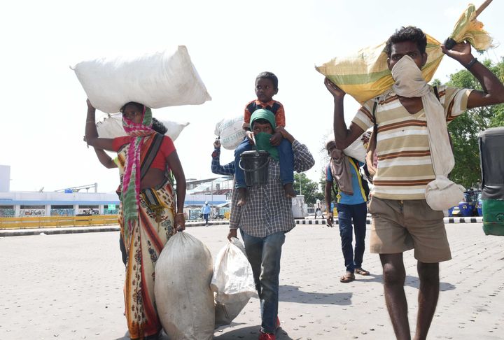 Migrants who have been travelling from Kolkata to their homes in Gumla district on foot or with the help of commercial vehicles are seen in search of a bus, at Hatia railway station on May 18, 2020 in Ranchi, India.