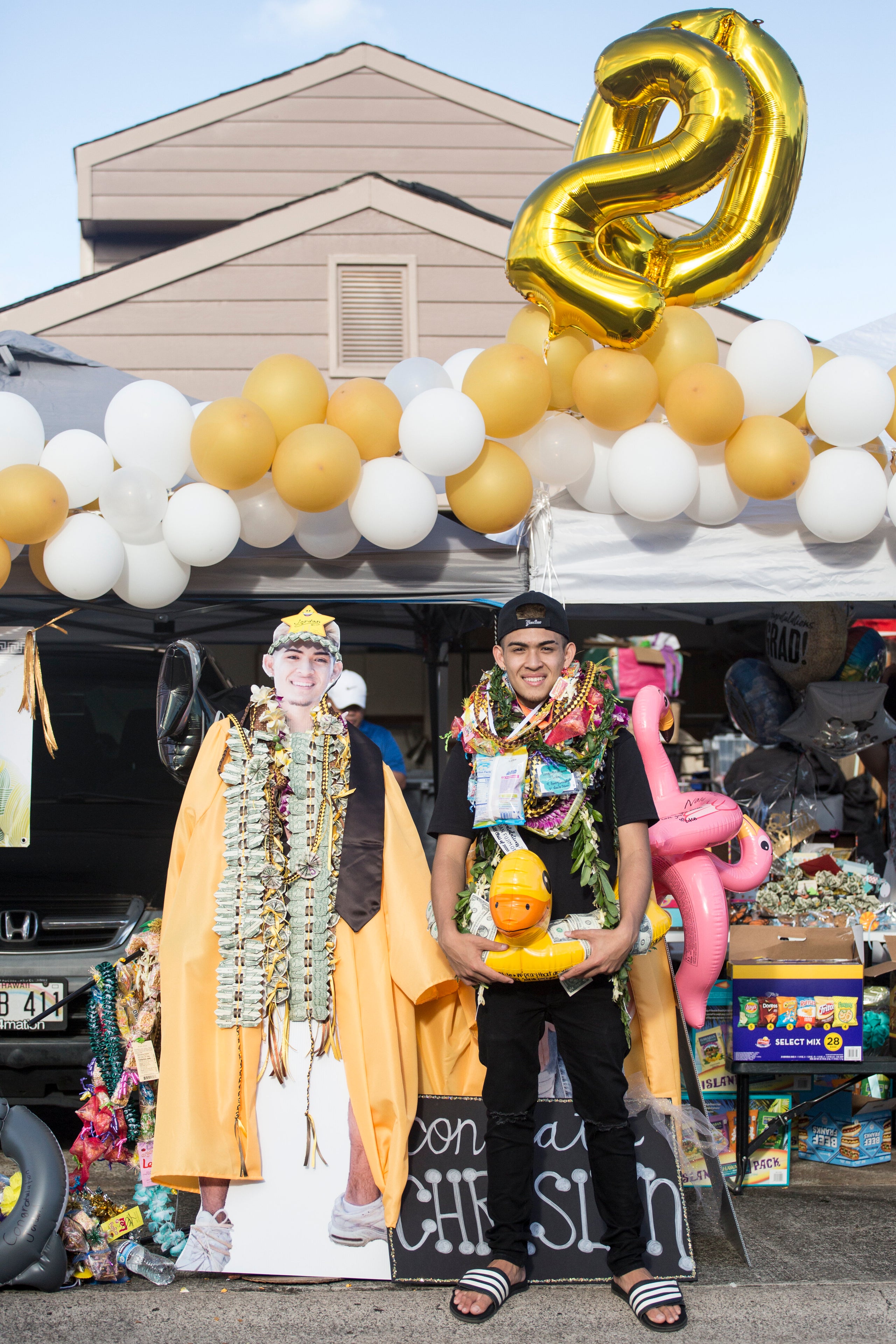 Jordan Fujimoto,&nbsp;a Mililani High School graduate, poses during his drive-by lei ceremony in Mililani, Hawaii, on May 17.