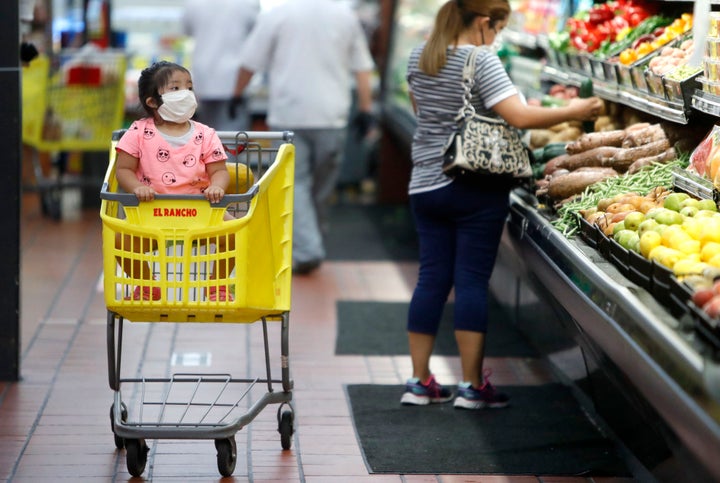 Amid concerns of the spread of COVID-19, a little girl wears a mask at El Rancho grocery store in Dallas on May 12, 2020.