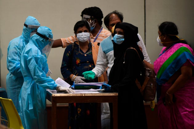 Health officials check the documents of citizens evacuated from Dubai by an Air India flight as they...