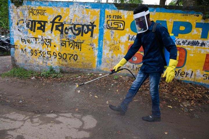 Member of the cleaning staff disinfect a street in Tehatta, Nadia, West Bengal, India on May 27, 2020. (Photo by Soumyabrata Roy/NurPhoto via Getty Images)
