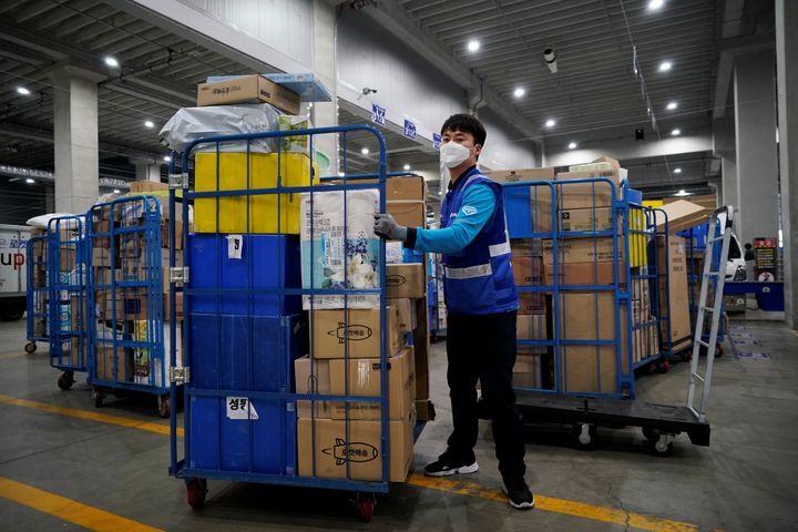 A delivery man for Coupang Jung Im-hong wearing a mask to prevent contracting the coronavirus, loads packages before leaving to deliver them in Incheon, South Korea, March 3, 2020. Picture taken on March 3, 2020. 