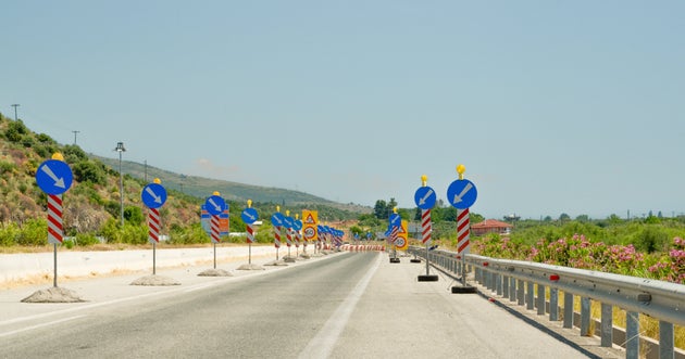 road works ahead on the street blue arrow round sign