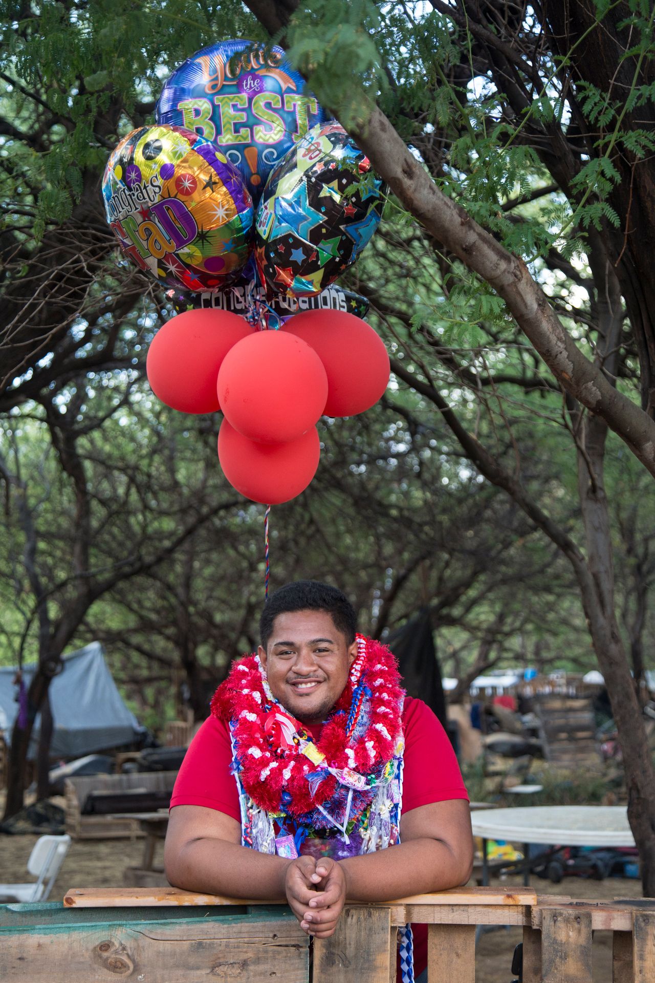Nainoa Brown-Kahananui, a Waiʻanae High School graduate, at the entrance of Puʻuhonua o Waiʻanae in Waiʻanae, Hawaii, on May 23. Brown-Kahananui has lived in what its residents call Oahu's largest "houseless village" for years.