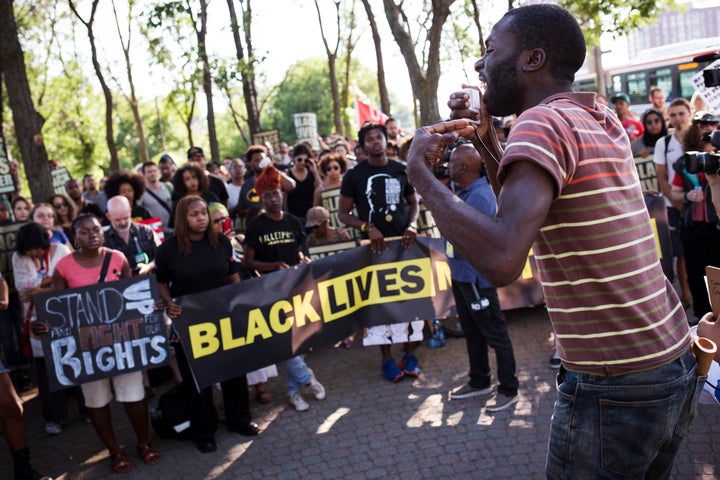 Desmond Cole addresses the crowd gathered at a Black Lives Matter protest on GIilbert Avenue in Toronto, where Andrew Loku was shot dead by police.