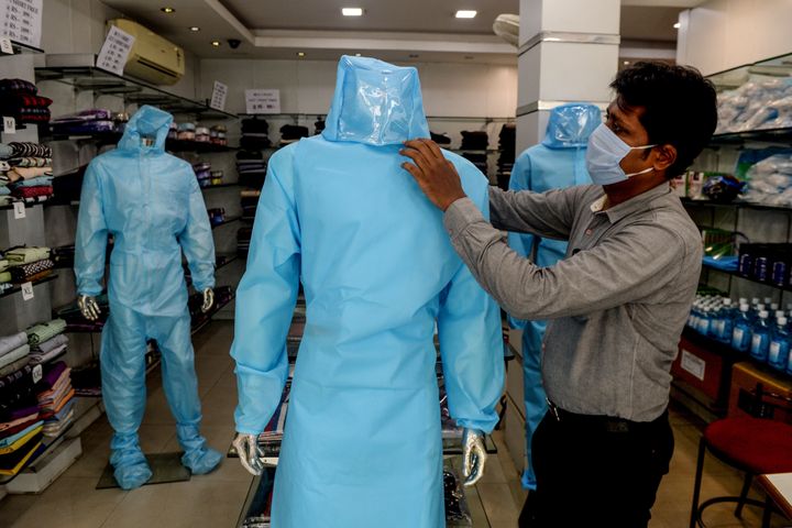 A shopkeeper arranges a protective suit for sale on a mannequin at a garment shop after the government eased a nationwide lockdown imposed as a preventive measure against the COVID-19 coronavirus, in Chennai on May 28, 2020.
