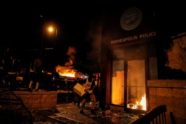 A protester sets fire to the entrance of a police station in Minneapolis. REUTERS/Carlos Barria