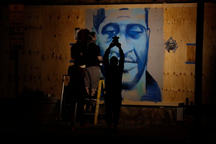 An artist creates an image of George Floyd in Minneapolis. (AP Photo/Julio Cortez)