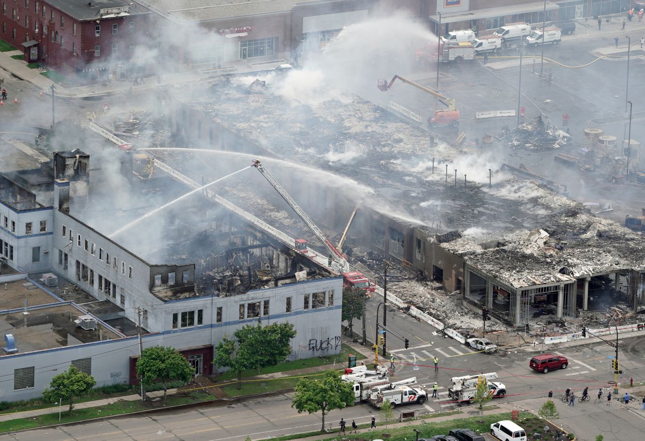 Firefighters work on an apartment building after it was burned to the ground in Minneapolis.