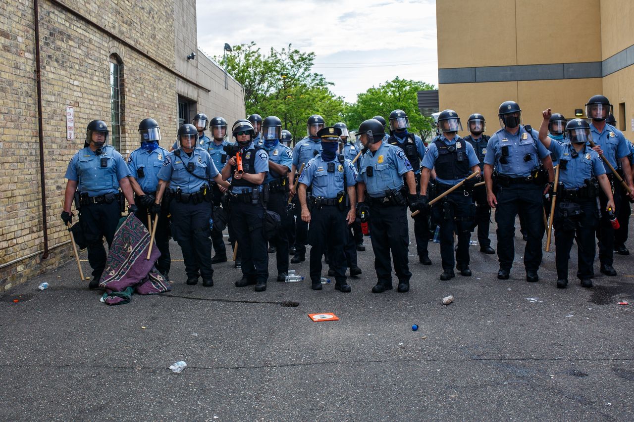 Police officers stand in a line while facing protesters demonstrating against the death of George Floyd outside the 3rd Precinct Police Precinct on May 27.