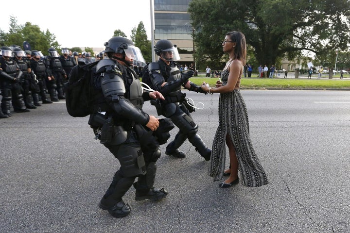 Lone activist Ieshia Evans stands her ground while offering her hands for arrest as she is charged by riot police during a July 2016 protest against police brutality in Baton Rouge, Louisiana. Evans, a 28-year-old Pennsylvania nurse, traveled to Baton Rouge to protest the death of Alton Sterling, a Black father who was shot at close range by two white police officers.