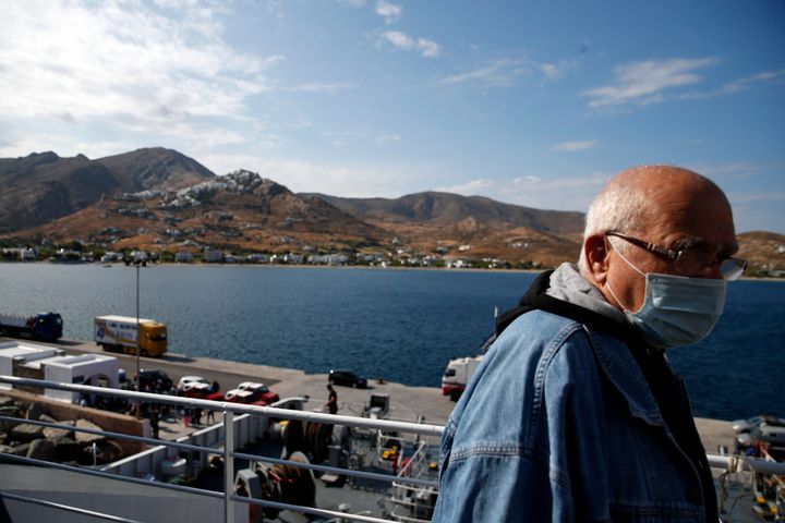 Επιβάτης σε καράβι με μάσκα, κοντά στο λιμάνι της Σερίφου. 
