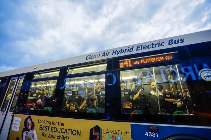 Police stand among protesters detained on a bus in Brooklyn on May 29.