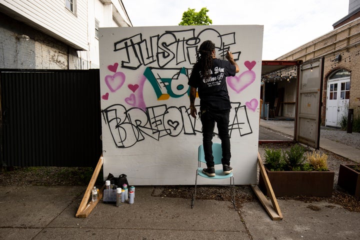 Grafitti artist Resko paints a mural near where a protest march started on May 29 in Louisville, Kentucky.