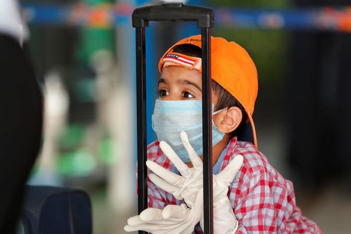 A child wearing a protection mask and gloves is seen at Indira Gandhi International airport on May 25, 2020.