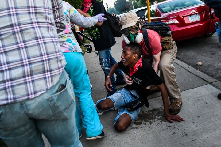 A protestor is assisted by medic protestors after being hit by tear gas near the 5th police precinct during a demonstration to call for justice for George Floyd, a Black man who died while in custody of the Minneapolis police, on May 30, 2020 in Minneapolis, Minnesota. (Photo by CHANDAN KHANNA/AFP via Getty Images)