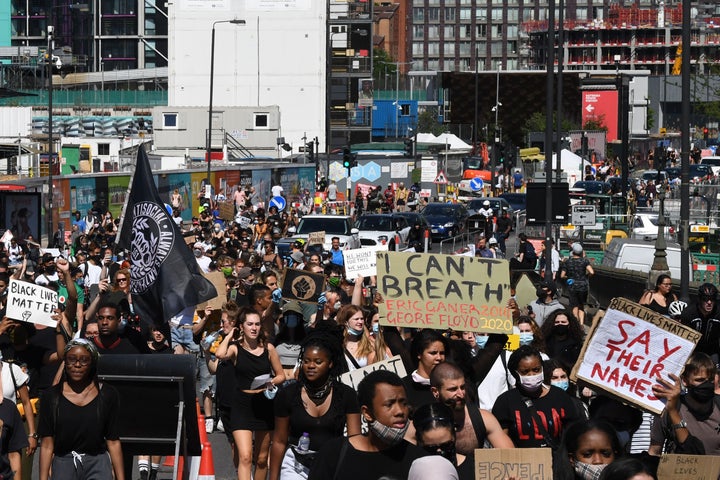 Demonstrators carry placards as they march in the road near the U.S. Embassy in central London on Sunday. 