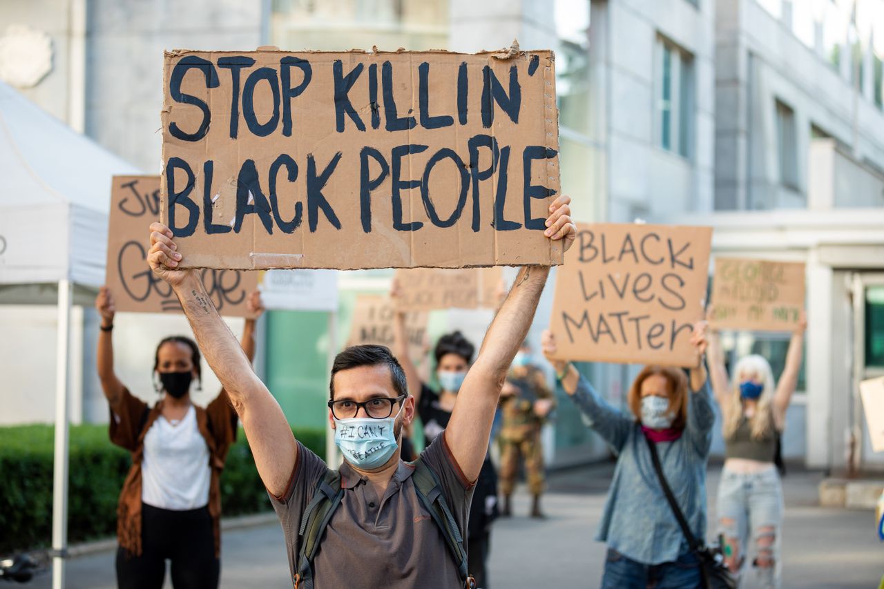 Διαδηλωτές στο Μιλάνο με πινακίδες και μάσκες διαμαρτύρονται για τον θάνατο του Τζόρτζ Φλόιντ από αστυνομικούς στις Ηνωμένες Πολιτείες. 