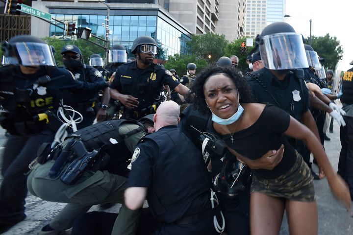 Police detain demonstrators protesting in Atlanta on Saturday. The protest started peacefully earlier in the day before demonstrators clashed with police.