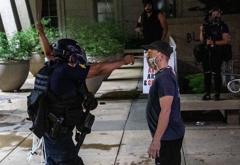 A protester is pepper-sprayed at point blank range as police in riot gear deployed tear gas, pepper spray and smoke bombs against demonstrators in downtown Raleigh on May 30, 2020.
