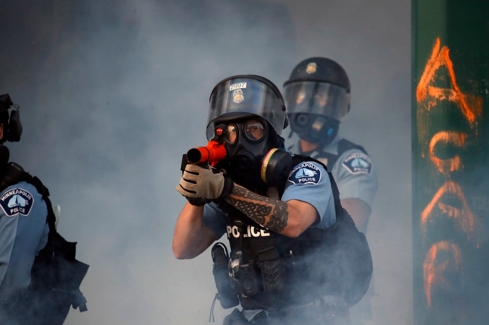A police officer prepares to shoot tear gas on on May 29, 2020. in Minneapolis. Protests continued following the death of George Floyd who died after being restrained by Minneapolis police officers on Memorial Day.