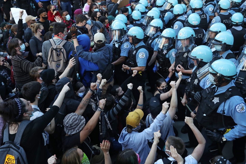 Police officers guarding the Trump International Hotel & Tower in Chicago hold back protesters on May 30, 2020 during a rally and march to remember the May 25 death of George Floyd.