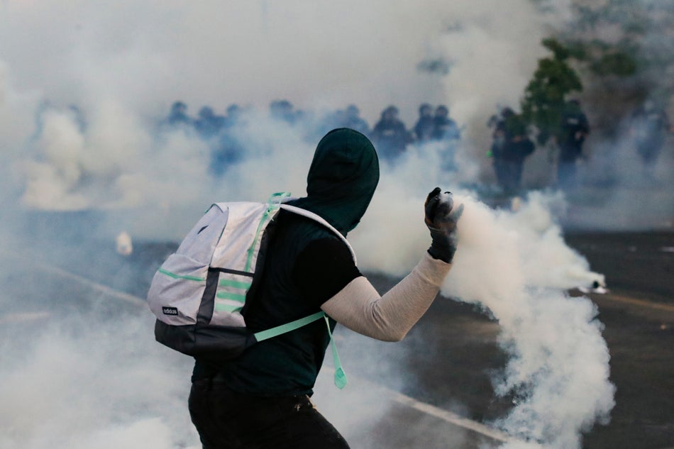 A protester throws a tear gas canister back at police on May 30, 2020 in Minneapolis.