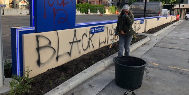 Joan Nicolai, the gardener at Gate City Bank in downtown Fargo, North Dakota, pauses to catch her breath during an early morning cleanup on Sunday.