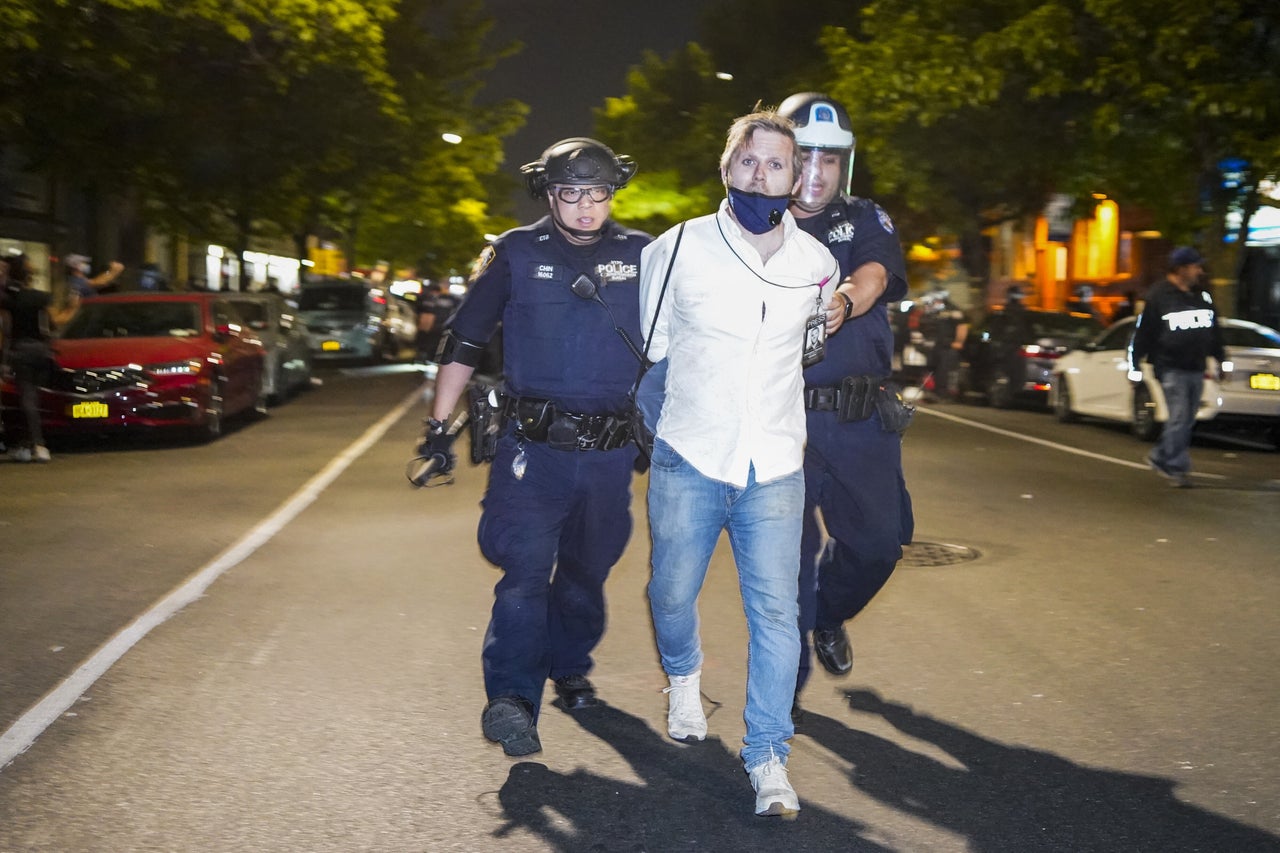 HuffPost senior reporter Christopher Mathias is taken into custody after being roughed up while covering the clash between police brutality protesters and New York Police Department officers on Saturday.