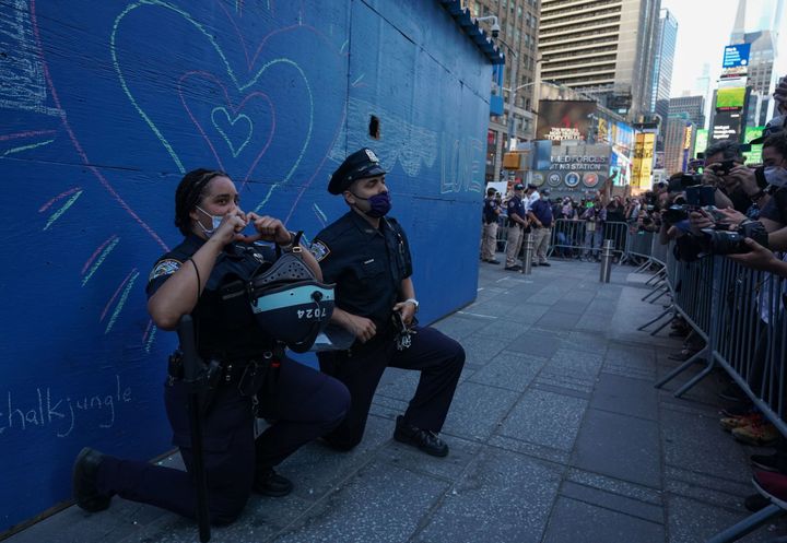 5月31日にニューヨーク・タイムズスクエアで行われた抗議活動の間、片膝をつくニューヨーク市警の警察官