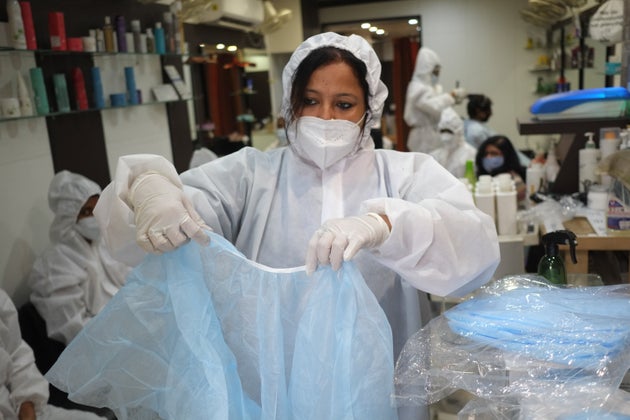 Women hairdressers working in a parlour were seen performing their duties wearing PPE suits along with...