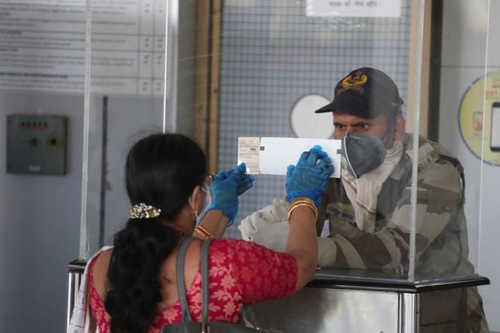 A passenger shows her ticket and identity card to a security personal at the airport in Ahmedabad on May 25, 2020.
