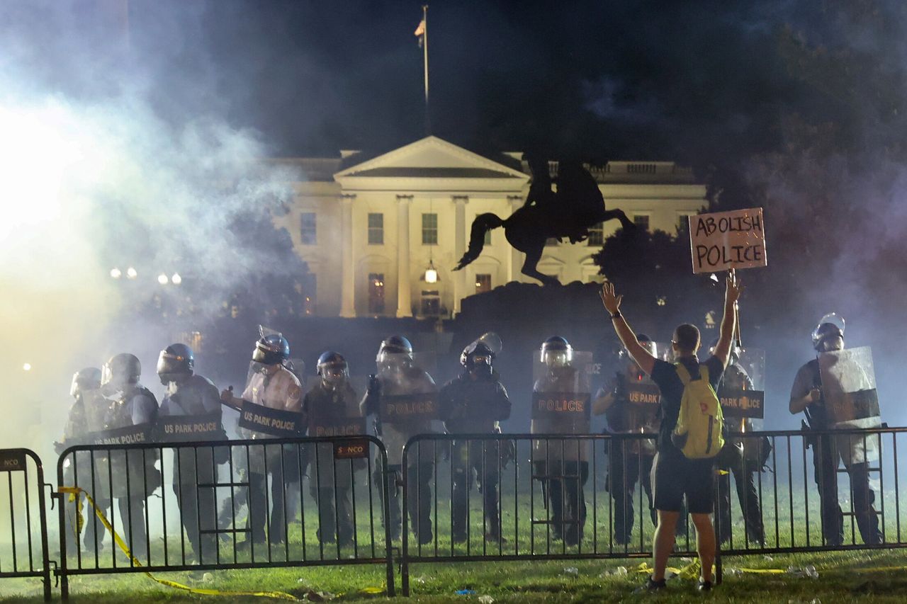 Police in riot gear keep protesters at bay in Lafayette Park near the White House in Washington on Sunday night.