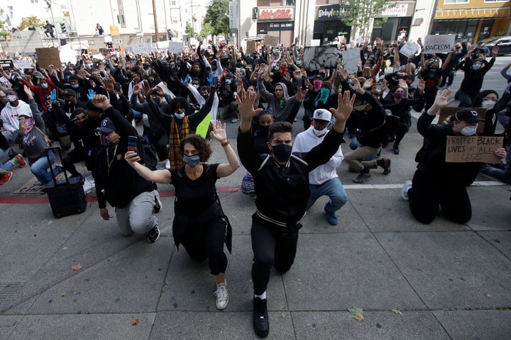 People kneel in front of the Hall of Justice in San Francisco, Sunday, May 31, 2020, at protests over the Memorial Day death of George Floyd. (AP Photo/Jeff Chiu)