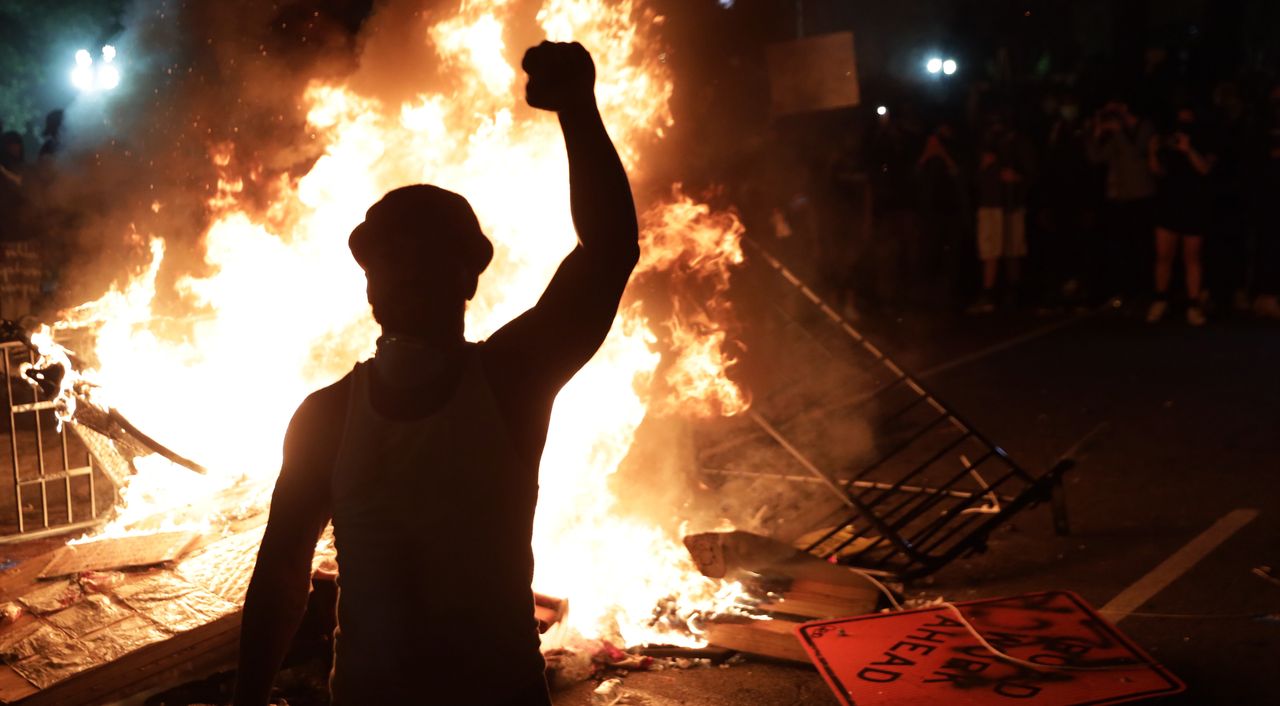 Demonstrators stand around a fire during a protest on May 31 near the White House in response to the killing of George Floyd.