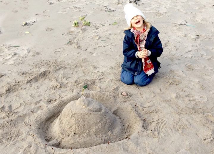 Daniel Brooks daughter building sandcastles on a beach