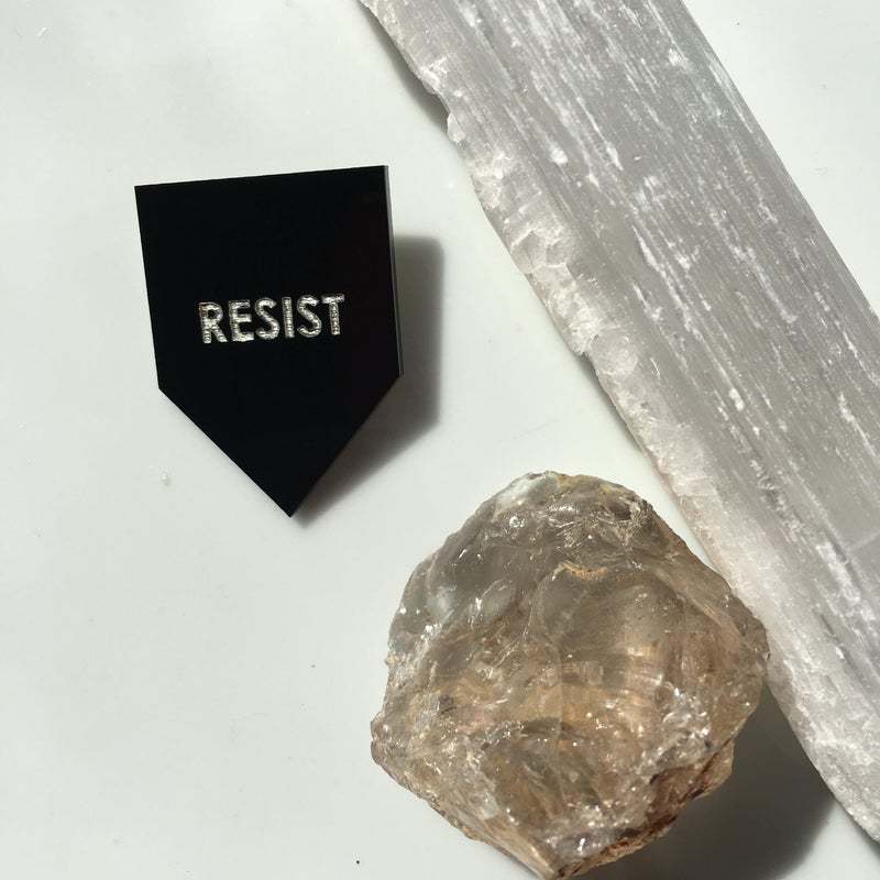 Get the "Resist" pin from Rayo & Honey for $12