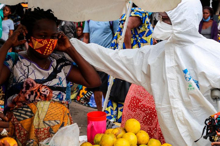 A street shop-keeper is receiving a face mask as a preventive measure against the spread of the COVID-19 coronavirus from a Filimbi activist in the city of Kinshasa on May 29.