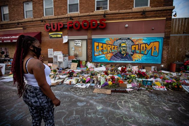 A woman pays her respects at the makeshift memorial and mural outside Cup Foods in Minneapolis on May