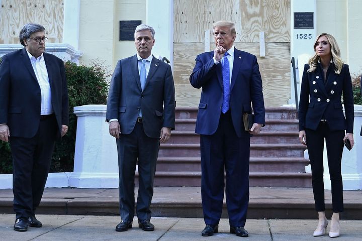 President Donald Trump holds a Bible as he stands with Attorney General William Barr, left, White House chief of staff Mark Meadows and White House press secretary Kayleigh McEnany at St. John's Episcopal Church across from Lafayette Park in Washington. 