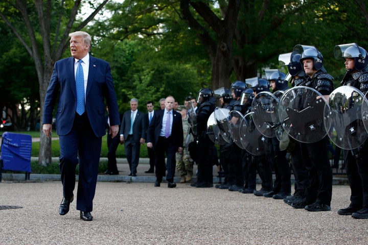 President Donald Trump walks past police in riot gear in Lafayette Park after he stood for photos Monday in front of St. John's Episcopal Church.